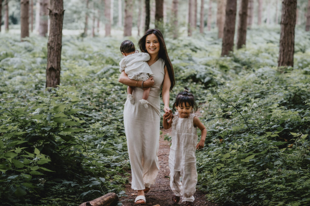 mum and daughters walking through forest